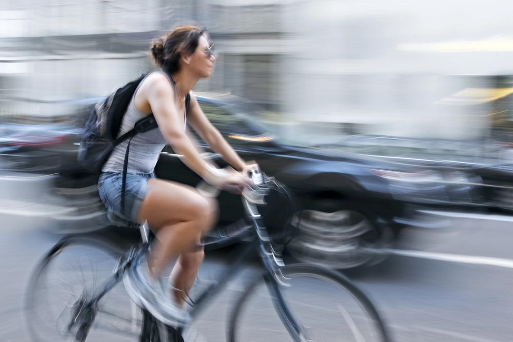 Car door opening in front of a cyclist, showing the dangers of dooring accidents.