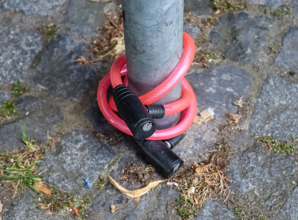 A cyclist locking their bike securely to a bike rack in Chicago to prevent theft.