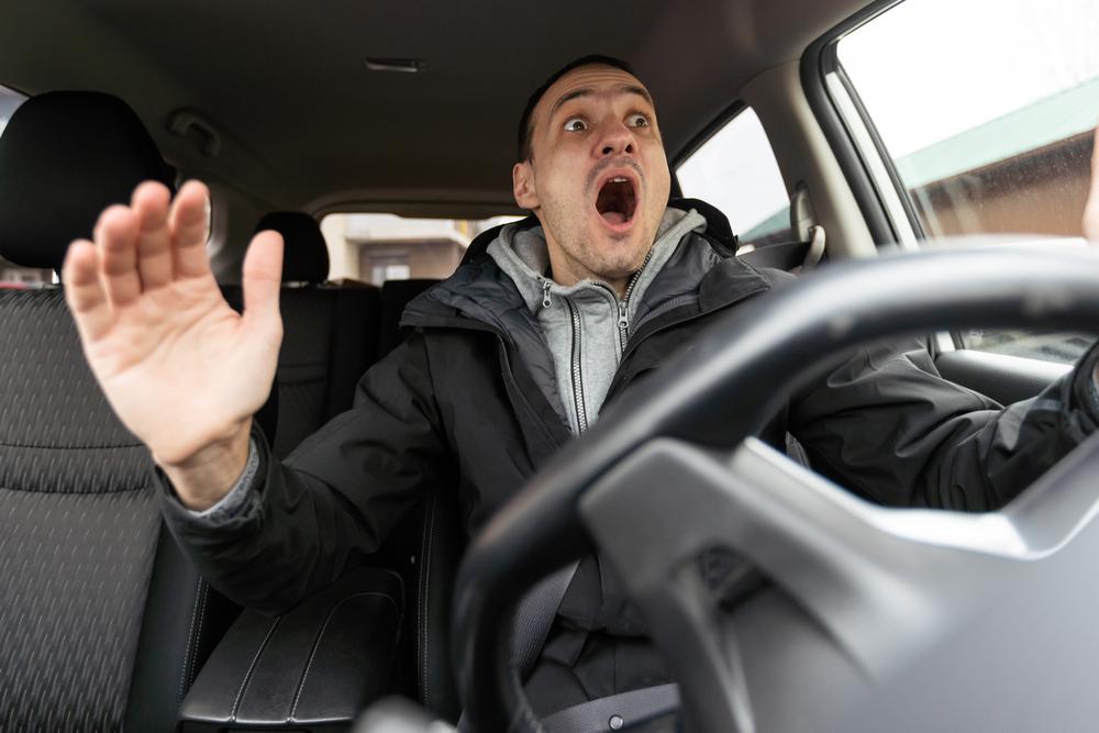 An angry driver confronting a cyclist, highlighting road rage dangers.