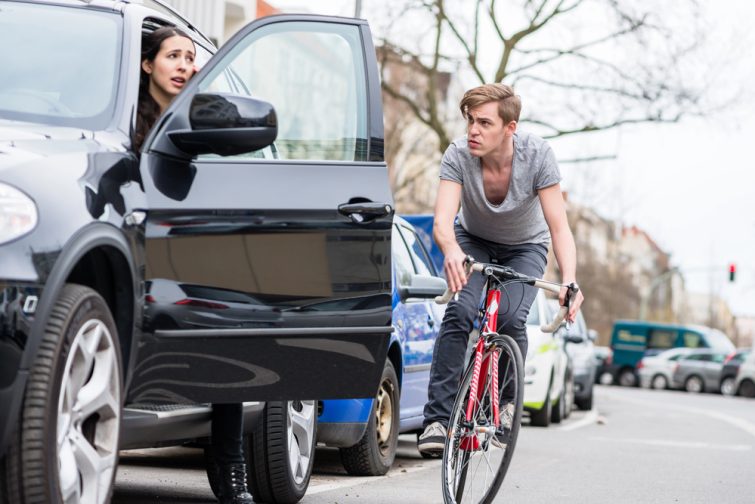 Driver using the Dutch Reach method to prevent bicycle dooring accidents in Chicago.