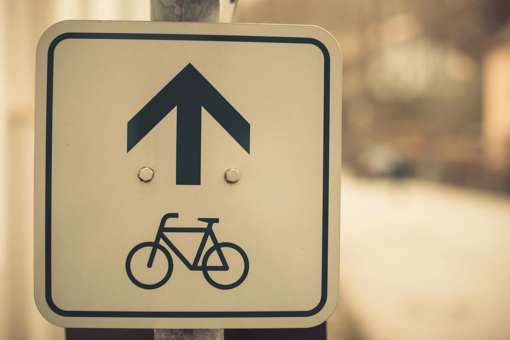 Sign indicating bike lane direction in Chicago, highlighting important Chicago bicycle accident laws and regulations, as advocated by Chicago bike accident lawyers for cyclist safety and legal rights.